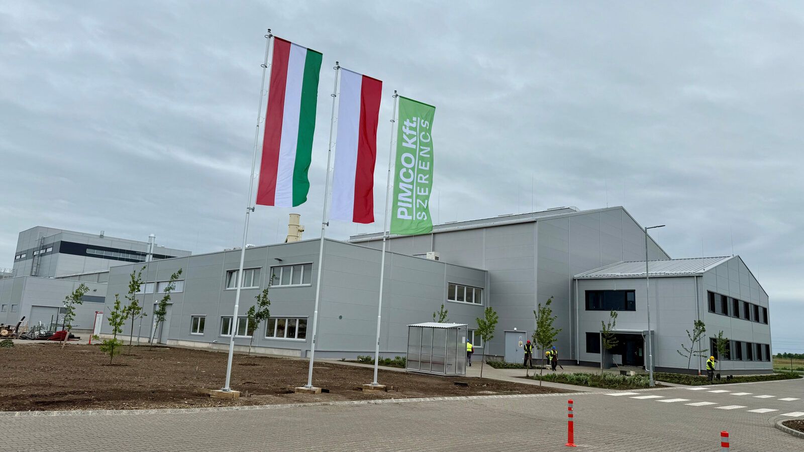 A szerencsi PIMCO üzem épülete, előtte zászlósorral